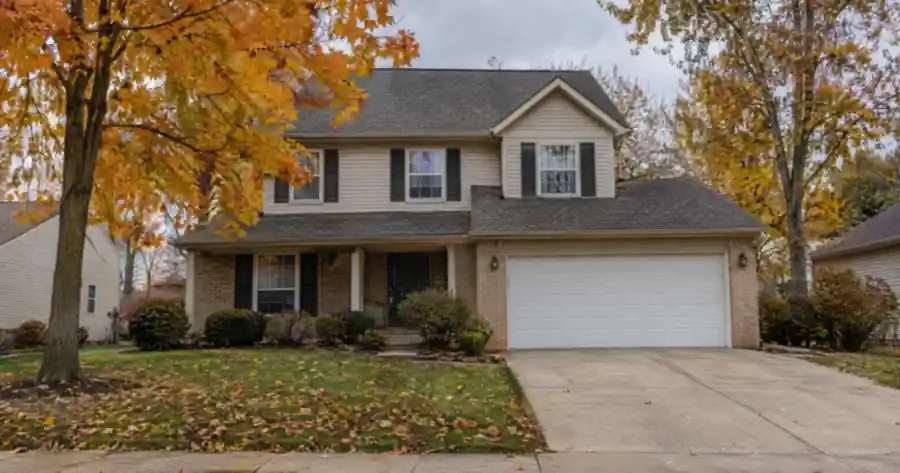 Two story home with a white double garage door in Holland, Ohio